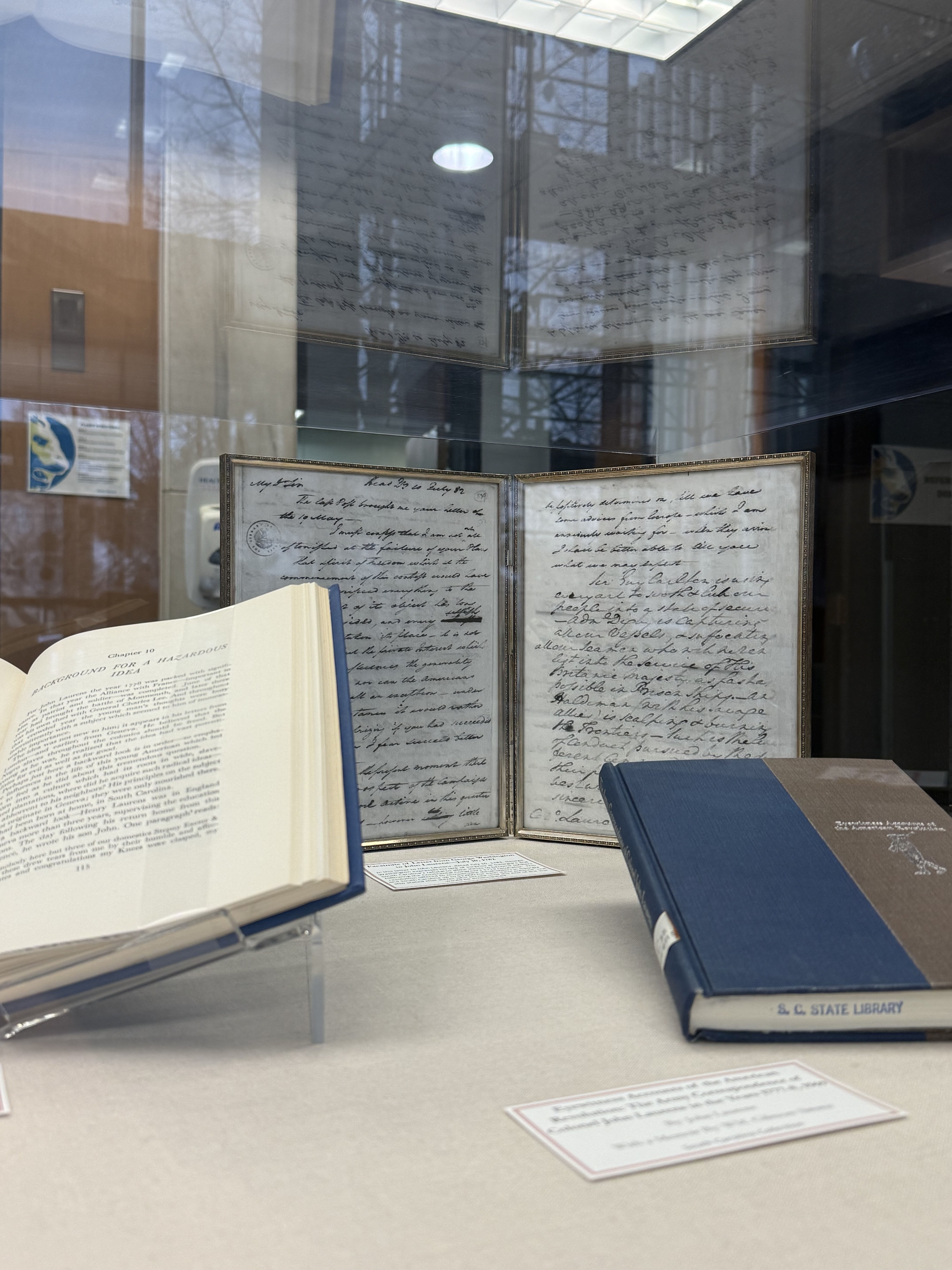 Open book and writings in a frame for our February display case.
