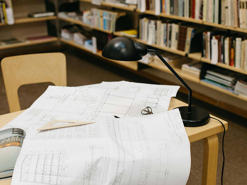 Desk in library with papers scattered all over.