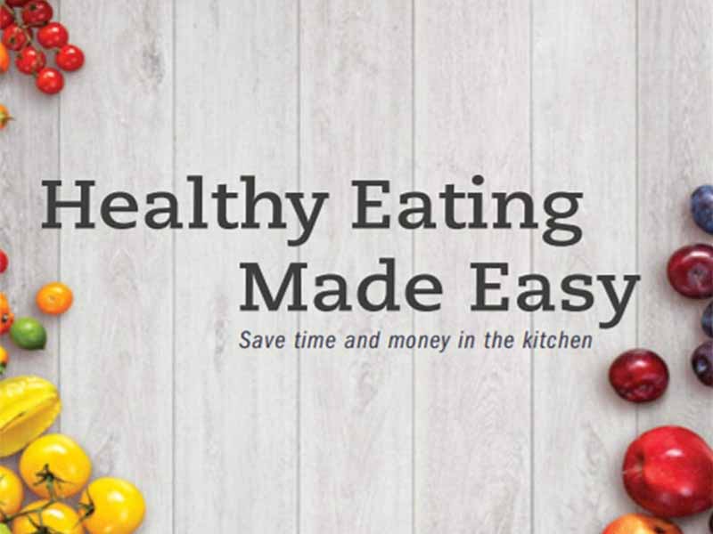 Cover of Healthy Eating Made Easy, text on a wooden surface with fruits and vegetables around the edges