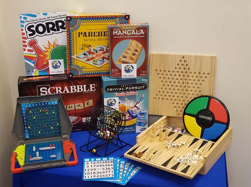 A selection of family board games on a blue table.