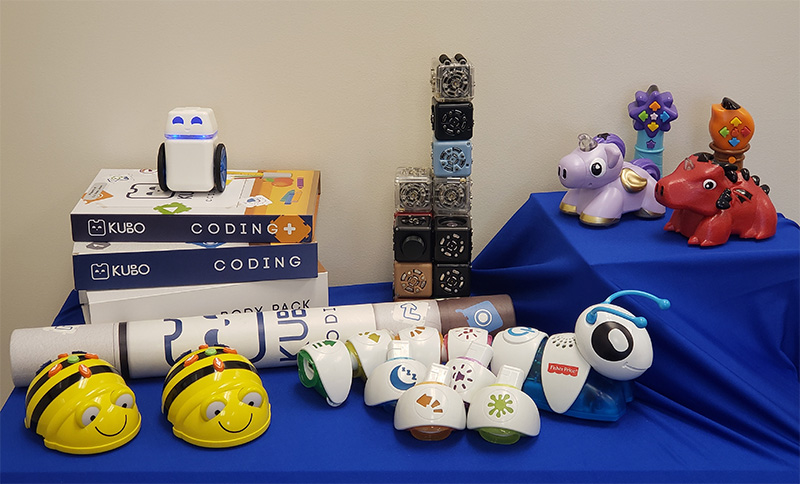 Various robot learning toys on a blue table.