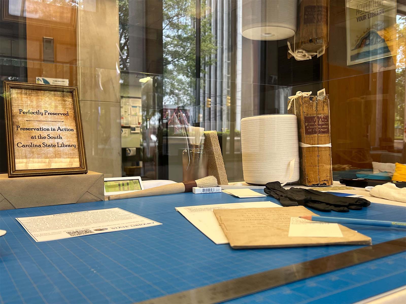 Preservation tools and a book in need of repair in our display case