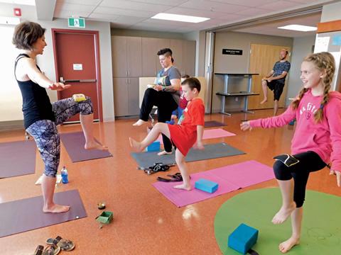 A woman leading kids in yoga.