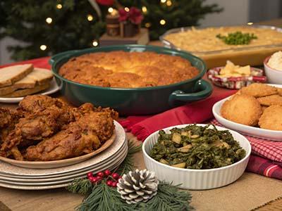 A table set with Southern foods, a Christmas tree is visible in the back